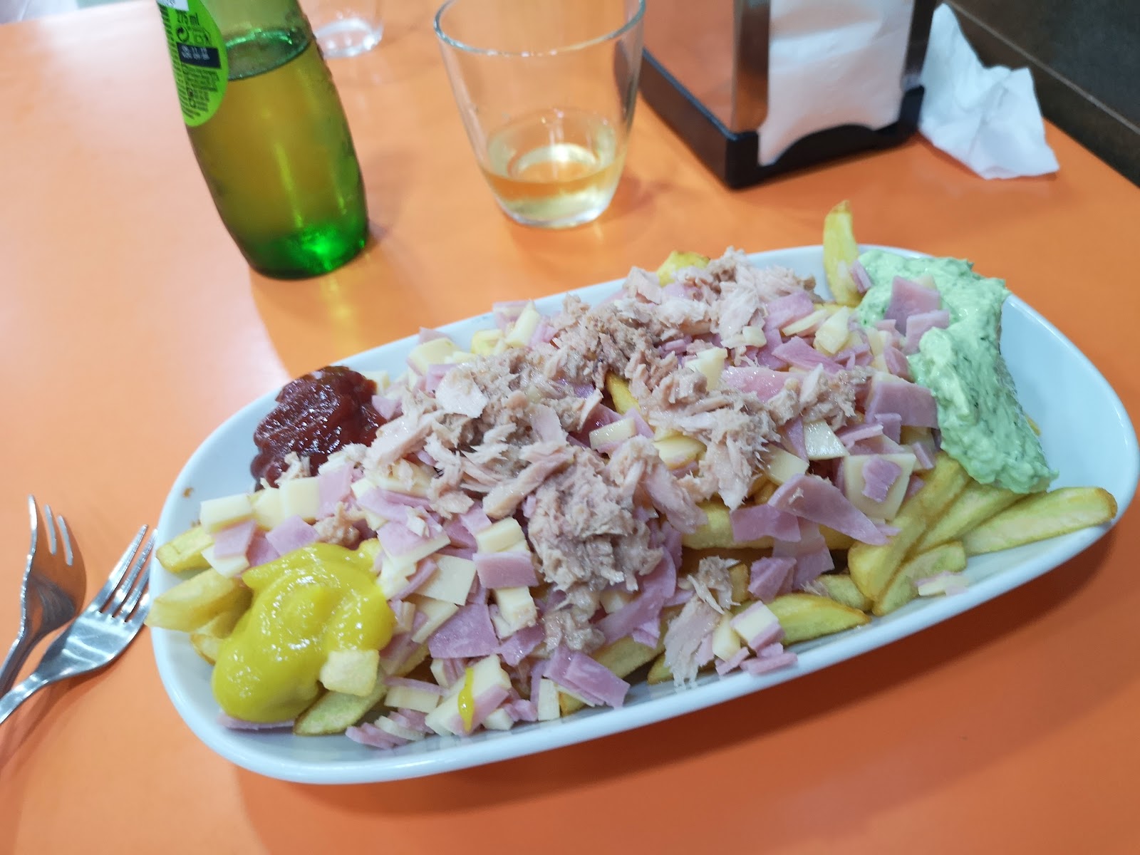 Plato para compartir repleto de carne, queso, millo y salsas.