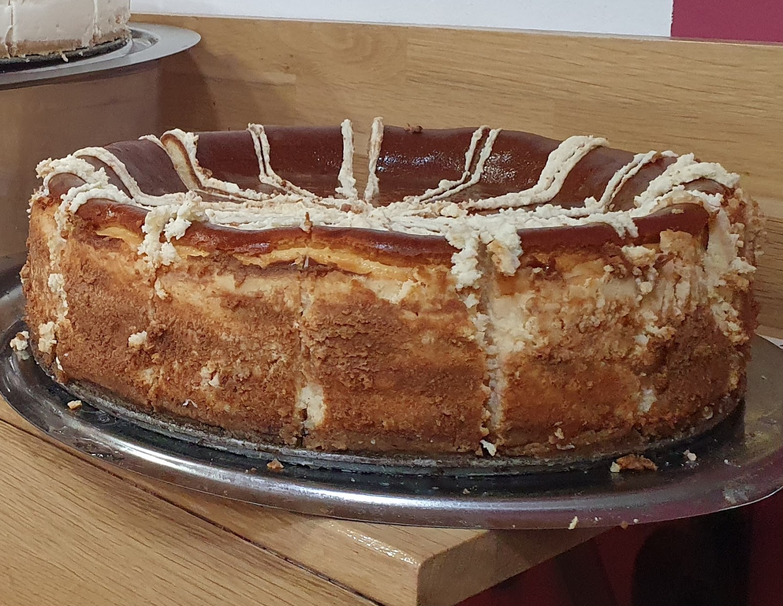 Nuestra tarta de queso decorada con líneas de dulce de leche.