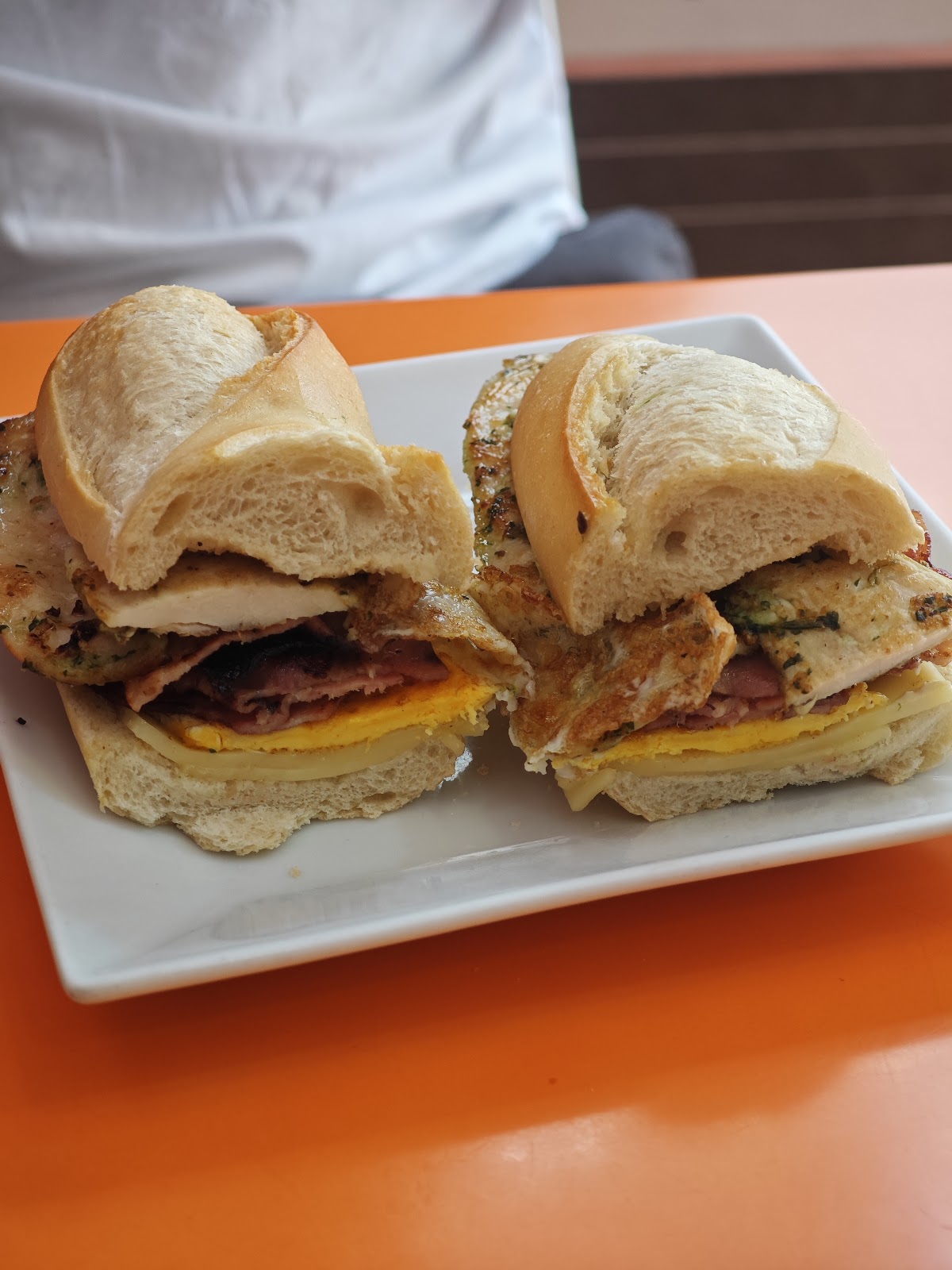 Bocadillo de pan tierno y crujiente cortado al centro.